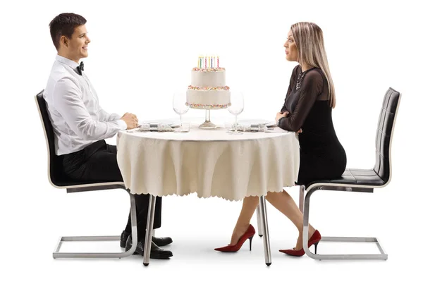 白い背景に孤立したテーブルの上にケーキと Restaurtant で若いカップル男の全長プロファイルショット — ストック写真