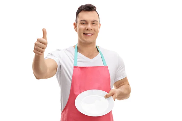 Young Guy Apron Showing Clean Plate Making Thumb Gesture Isolated — Stock Photo, Image