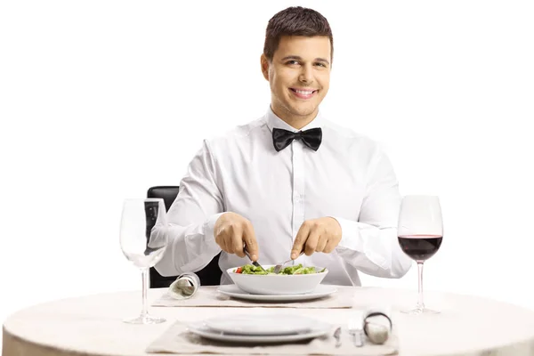 レストランのテーブルにサラダを食べて 白い背景で隔離のカメラで笑顔のハンサムな男 — ストック写真