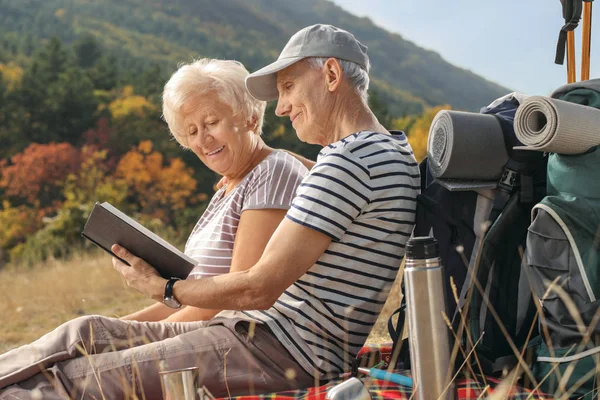 Caminhantes Seniores Com Mochilas Sentadas Cobertor Lendo Livro Uma Montanha — Fotografia de Stock