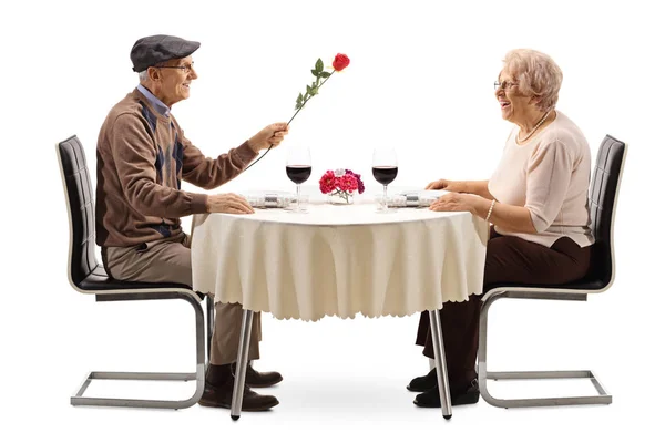 Старший Мужчина Дарит Красную Розу Пожилой Женщине Столом Ресторана Изолированным — стоковое фото