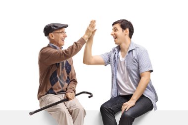 Üst ve genç adam üzerinde bir oturan ve yüksek-fiving birbirlerinin beyaz arka planda izole