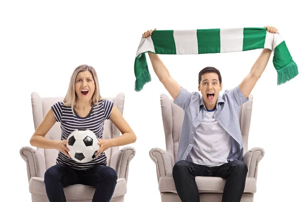 Soccer fans with a football and a scarf sitting in armchairs and cheering isolated on white background