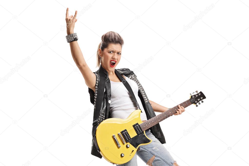 Punk girl with an electric guitar making a horn sign isolated on white background
