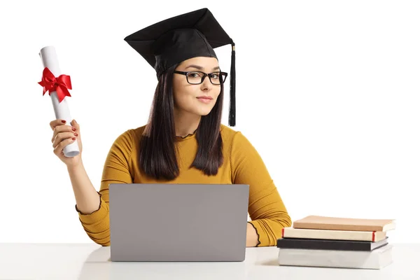 年轻的妇女与毕业帽子和文凭坐在与笔记本电脑和书查出在白色背景 — 图库照片