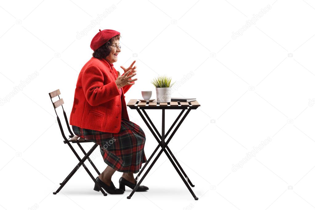 Surprised elderly woman drinking coffee at a table isolated on white background