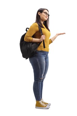 Beyaz arka planda el ele izole edilmiş bir şekilde duran ve el kol hareketi yapan bir kız öğrencinin tam boy çekimi.