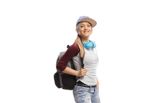 バックパックとヘッドフォンを持つ若い女性は白い背景に隔離されたポーズ — ストック写真