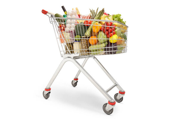 Shopping trolley filled with different food products, fruits and vegetables isolated on white background