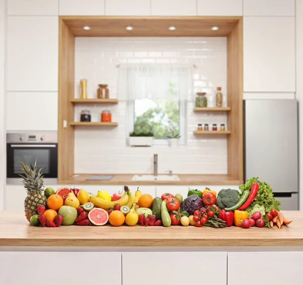 モダンなキッチンの木製カウンターに置かれた果物や野菜 — ストック写真