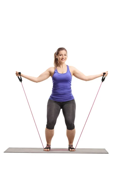 Young woman exercising with a resistance band and smiling at the — ストック写真