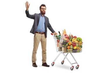 Bir alışveriş sepeti ile ayakta ve beyaz arka plan üzerinde izole sallayarak genç sakallı bir adamın tam uzunlukta portre