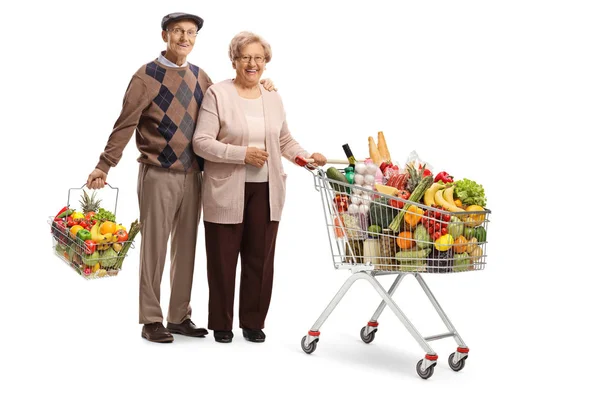 一对年长的夫妻与购物车和购物篮合影 白色背景上与食物隔离 — 图库照片