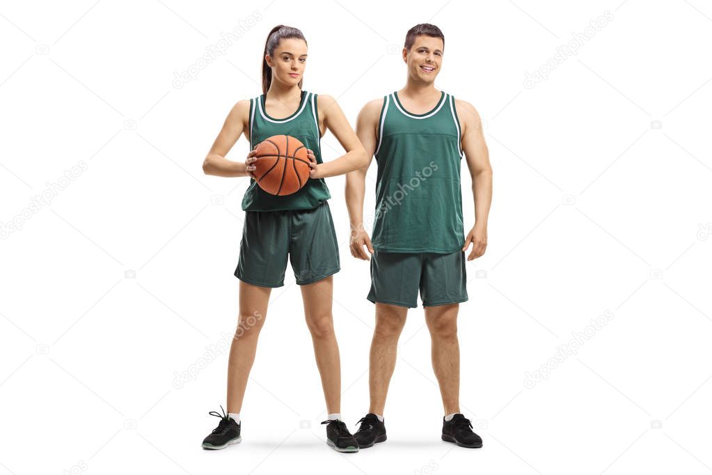 Full length portrait of a male and female basketball players posing isolated on white background