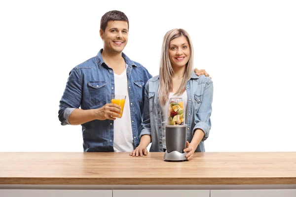 Young man and woman with fruits in a blender and a glass of juic — Stock Photo, Image