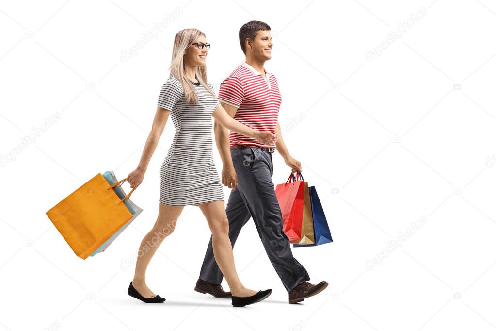 Young man and woman walking with shopping bags 