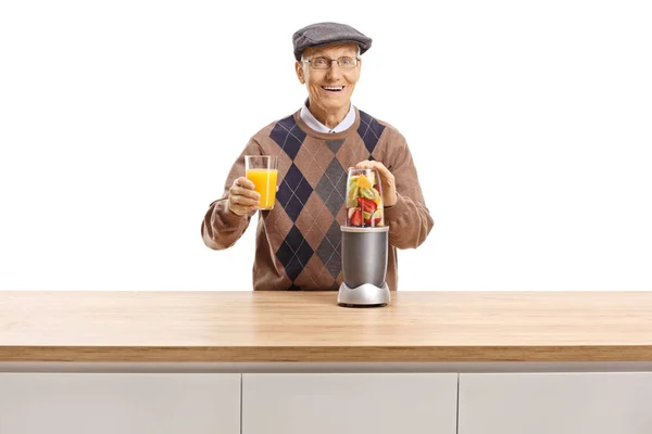 Hombre Mayor Alegre Preparando Fruta Una Licuadora Sosteniendo Vaso Jugo —  Fotos de Stock