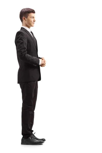 黒いスーツを着た男のフルレングスプロフィールショットは 白い背景に孤立して立って待っています — ストック写真
