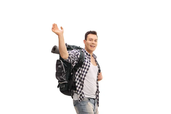 白い背景に隔離されたカメラで手を振るバックパックを持つ男性ハイカー — ストック写真