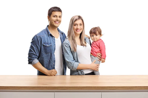 一个母亲 父亲和一个女婴的年轻家庭躺在一个白色背景的木制柜台后面 — 图库照片