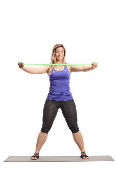 Young woman exercising with a stretching band — Stock Photo, Image