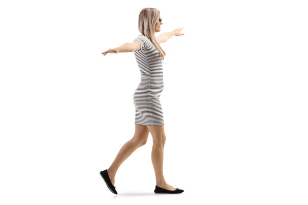 Jonge blonde vrouw lopen met armen verspreid — Stockfoto