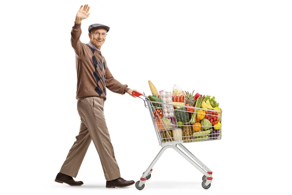 Anciano empujando un carro de compras y saludando —  Fotos de Stock
