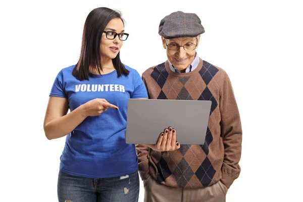 Jovem voluntária e mostrando um homem idoso um laptop — Fotografia de Stock