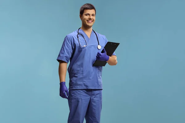 Giovane Medico Maschio Uniforme Indossando Guanti Tenendo Una Cartellina Isolata — Foto Stock