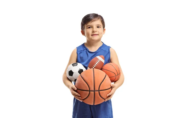 白い背景に隔離された異なるスポーツから多くのボールを保持する小さな男の子 — ストック写真