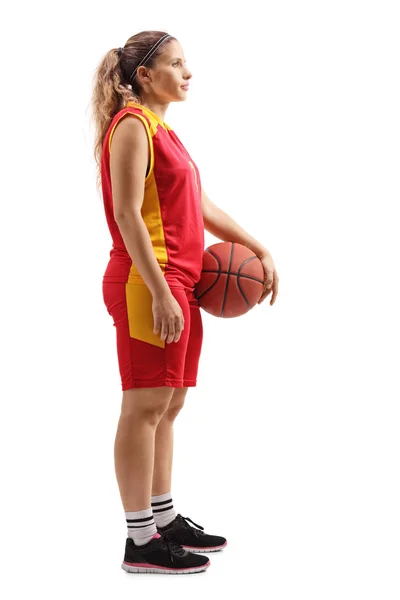 白い背景に隔離されたボールで立っている女性バスケットボール選手のフルレングスプロフィールショット — ストック写真