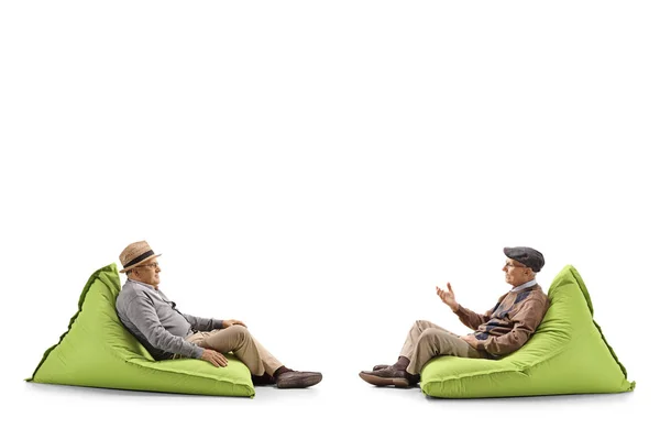 两名老人坐在豆袋上 在白色背景上隔离谈话的全长轮廓拍摄 — 图库照片