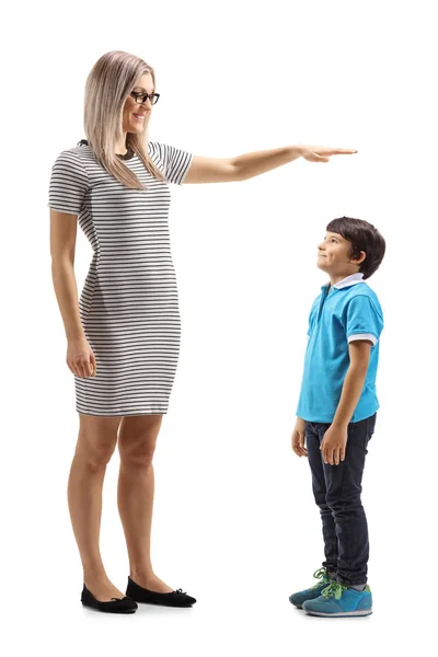 一个女人用手打手势的全长镜头 显示一个在白色背景上孤立的小男孩的高度 — 图库照片