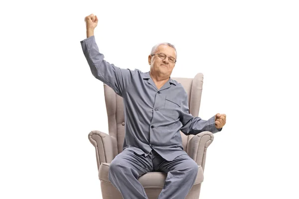 Volwassen Man Pyjama Zittend Een Fauteuil Stretching Geïsoleerd Witte Achtergrond — Stockfoto