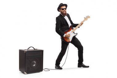 Beyaz arka plan üzerinde izole bir amfi takılı bir elektrik gitar çalan sakallı bir adamın tam uzunlukta çekim