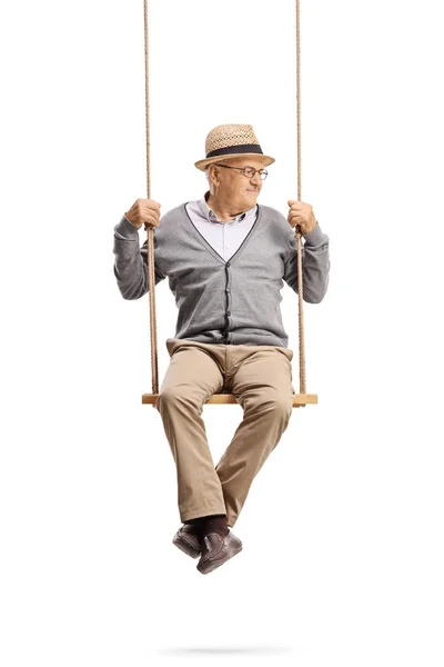 Mature gentleman sitting on a swing and looking to the side — Stock Photo, Image
