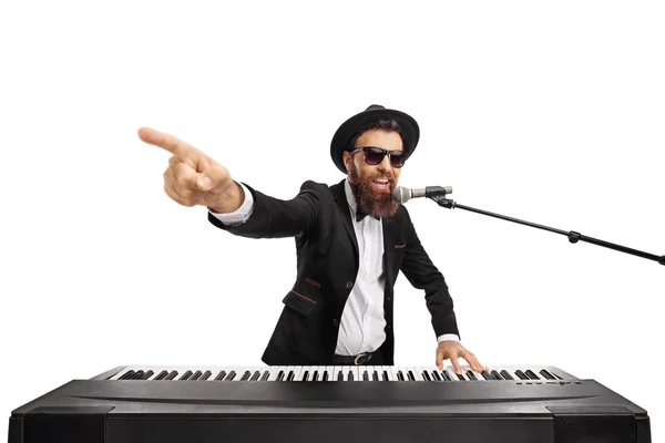 Чоловік грає на клавіатурі і співає на мікрофоні — стокове фото