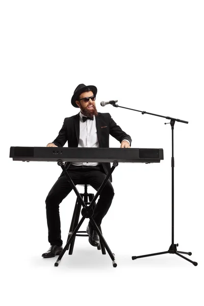 Musicista maschile che suona un pianoforte digitale e canta su un microfono — Foto Stock