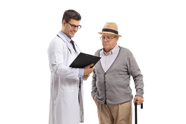 Doctor y un paciente mayor masculino mirando un portapapeles — Foto de Stock
