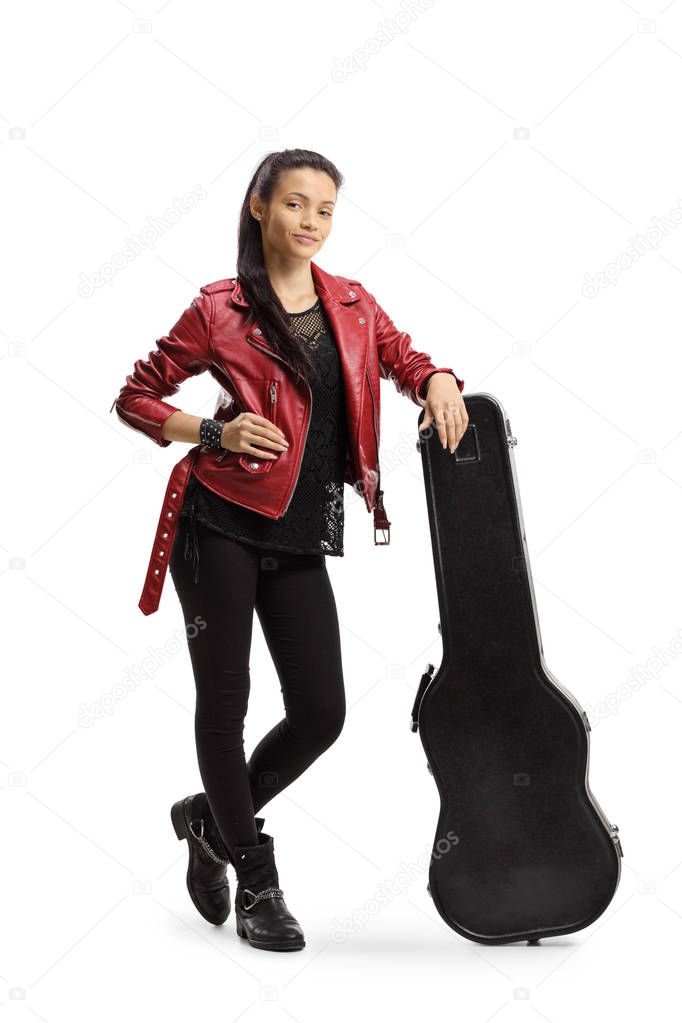 Young female musician leaning on a guitar case 