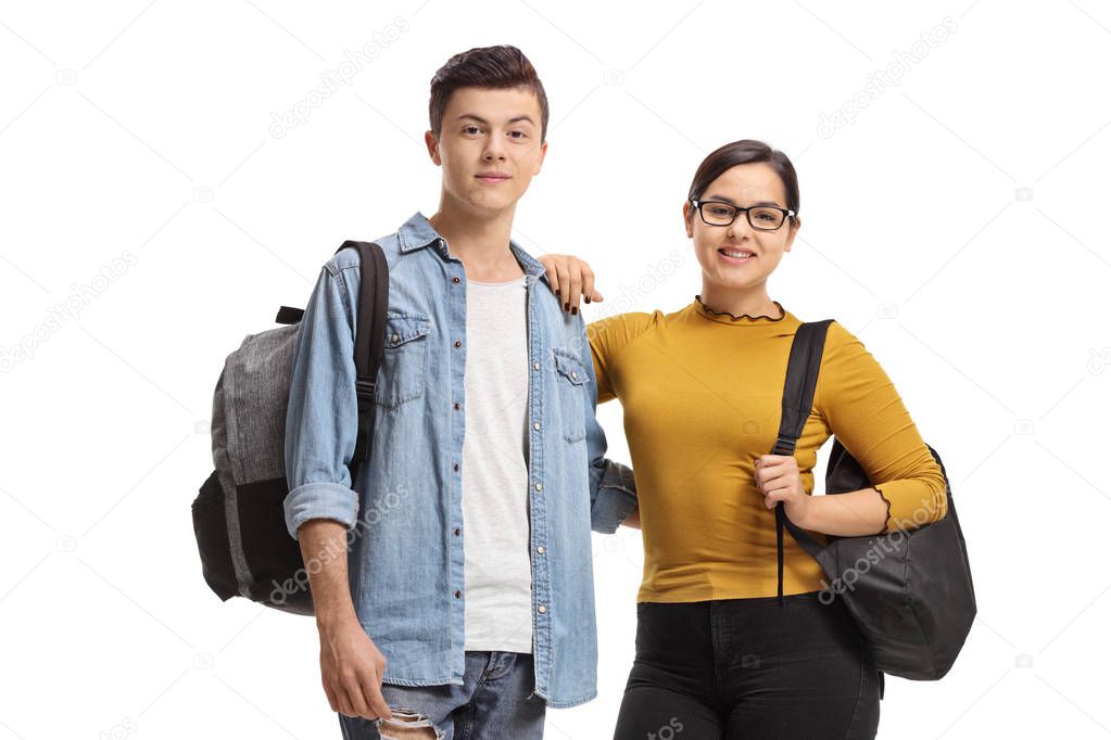 Male and a female student with backpacks smiling at the camera isolated on white background