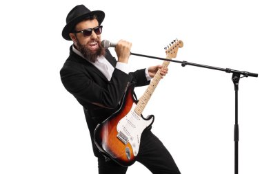 Beyaz arka plan üzerinde izole bir mikrofon tutan bir bas gitar ile bir erkek şarkıcı portresi 