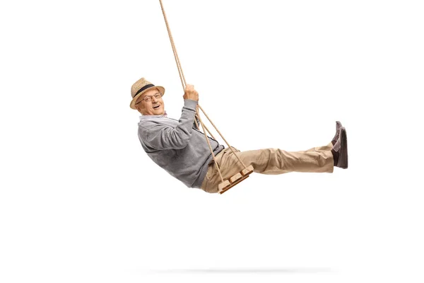 Happy senior swinging on a wooden swing — Stock Photo, Image