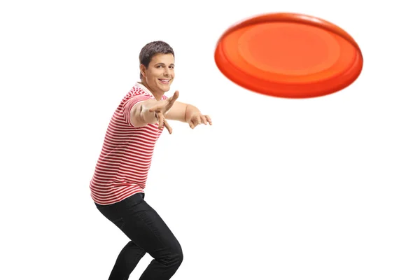 Młody przystojniak rzuca frisbee — Zdjęcie stockowe