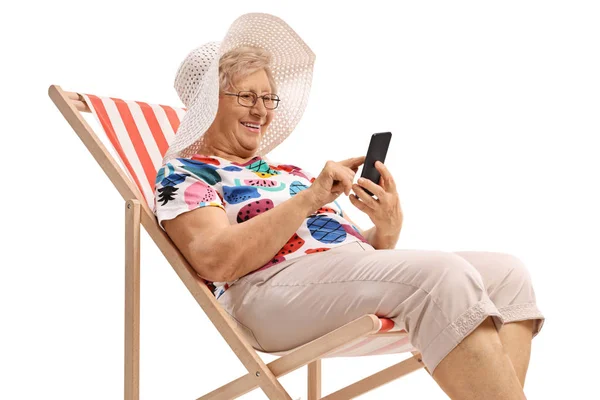 Senior Vrouw Zittend Een Ligstoel Kijken Naar Een Telefoon Geïsoleerd — Stockfoto