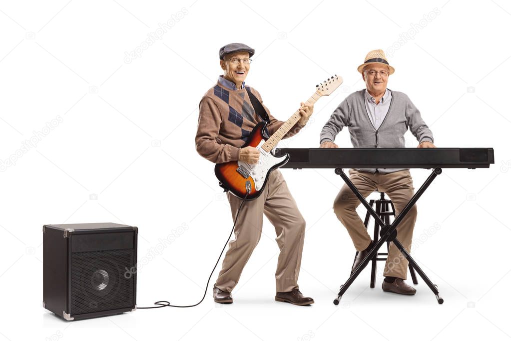 Full length portrait of two senior men playing keyboard and an electric guitar isolated on white background