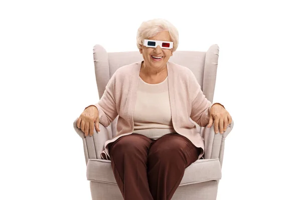 Oudere vrouw met 3D bril zittend in een fauteuil — Stockfoto