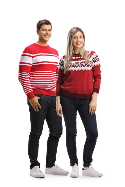 Joven hombre y mujer vistiendo jerséis rojos navideños y posando — Foto de Stock