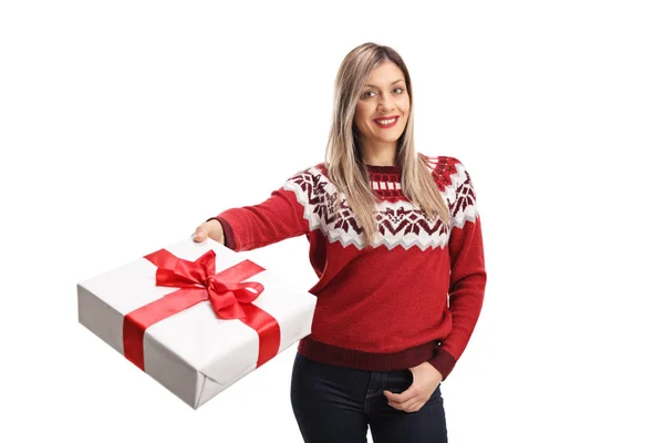 Młoda Wesoła kobieta ubrana w czerwony sweter i trzyma prezent — Zdjęcie stockowe