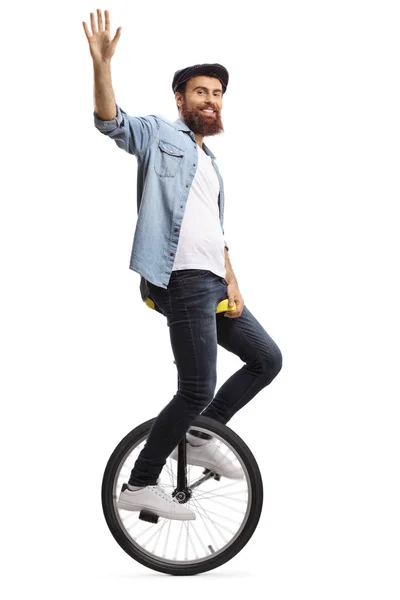 Barbuto ragazzo su un monociclo agitando a il fotocamera — Foto Stock